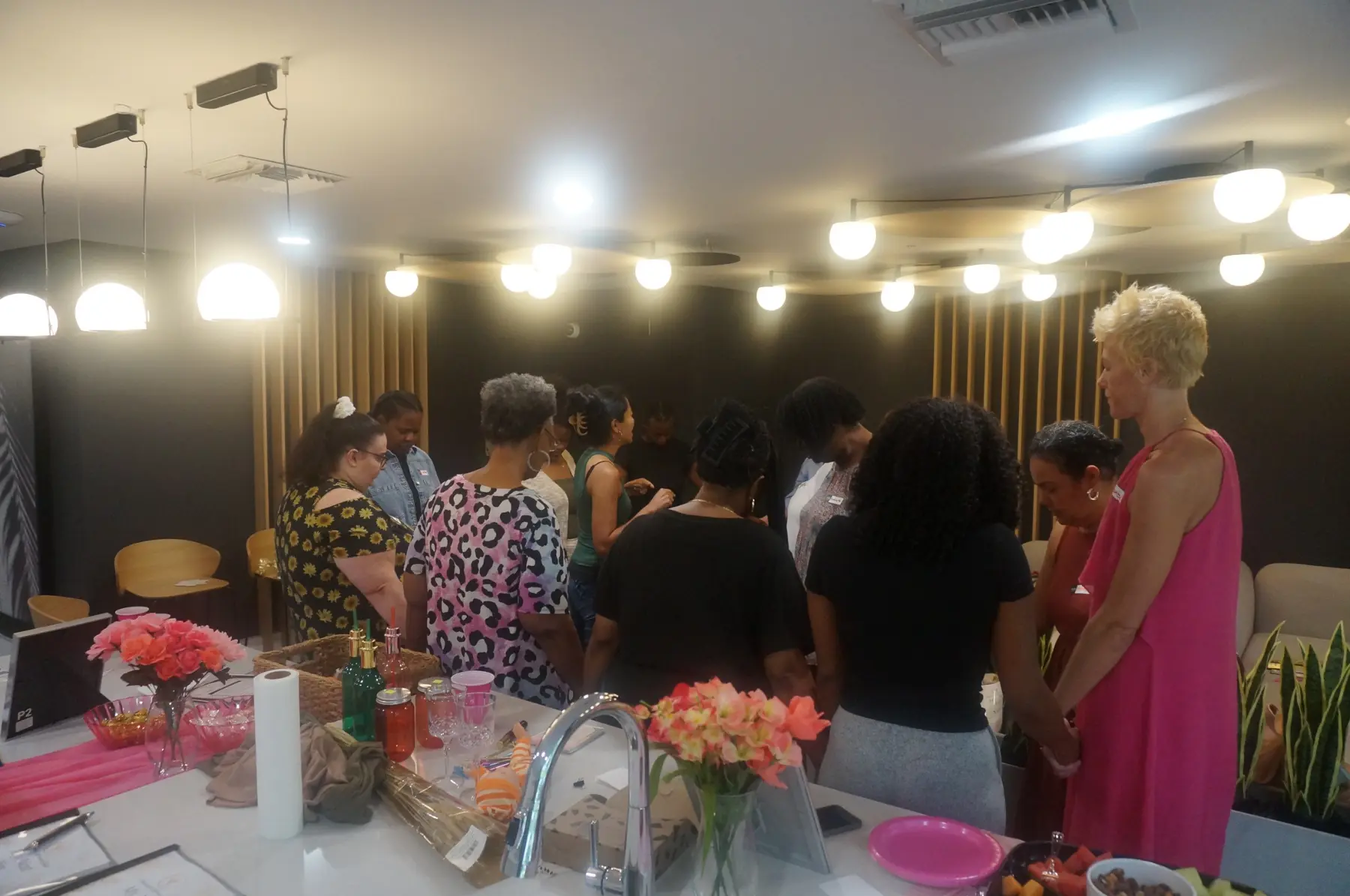 Women standing with heads bowed during closing prayer