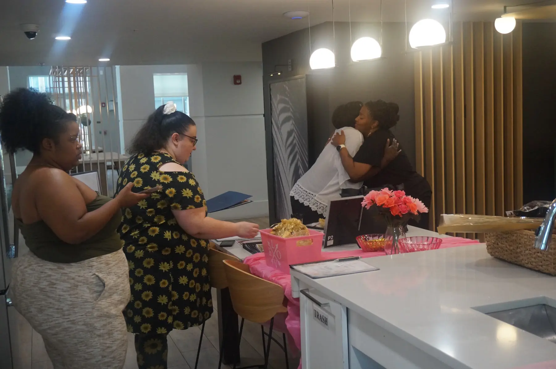 Two women embracing near the welcome table