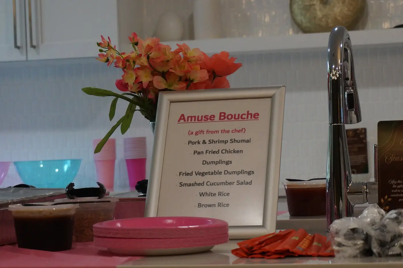 Amuse-bouche menu beside flowers and the serving table