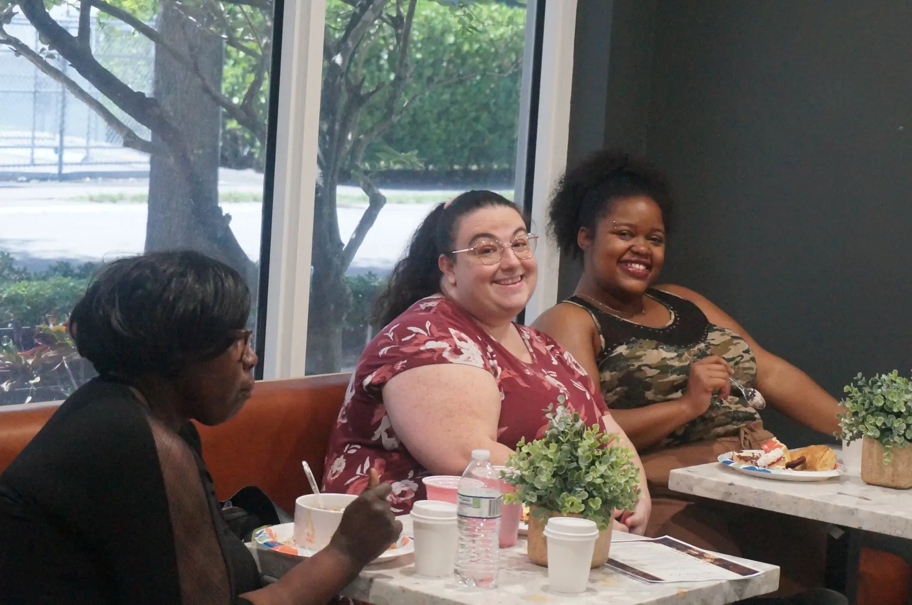 Women smiling together while seated around the table