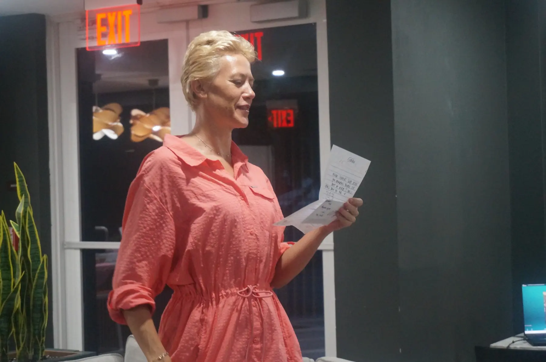 A woman in a coral dress sharing her reflections