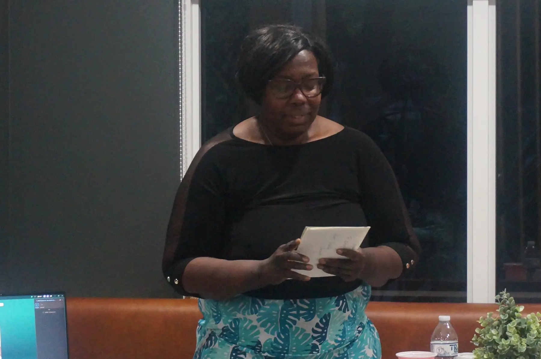 A woman standing before the group with her reflection card