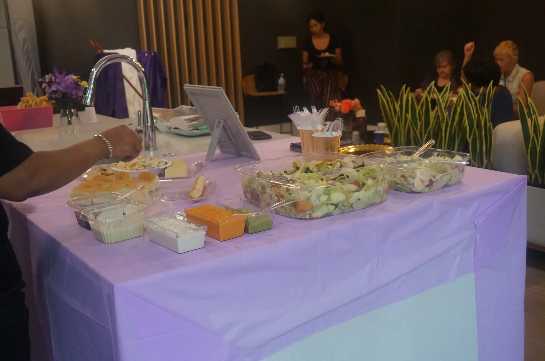 Salads, breads, and dressings arranged on the buffet