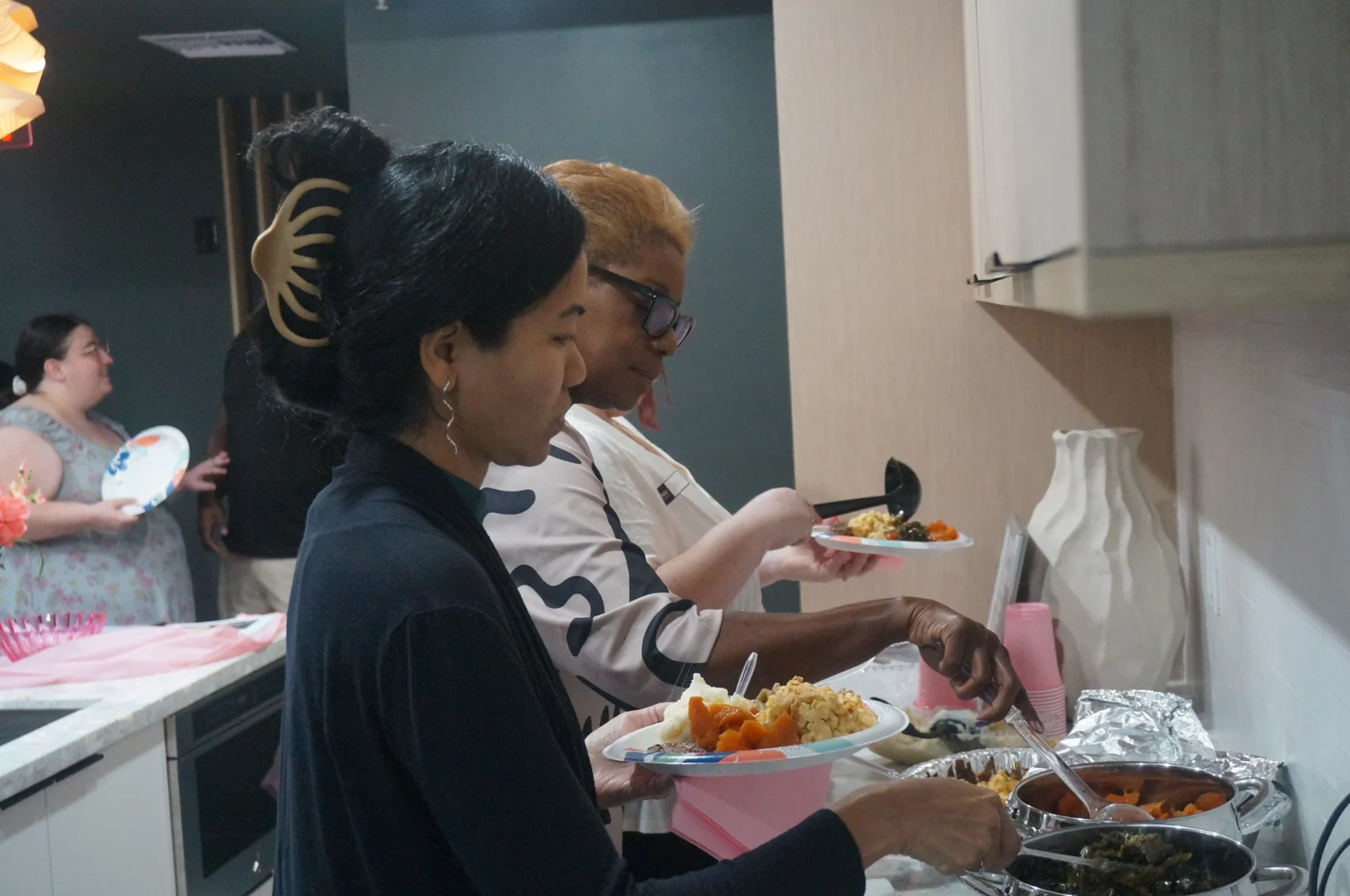 Women selecting food from the buffet