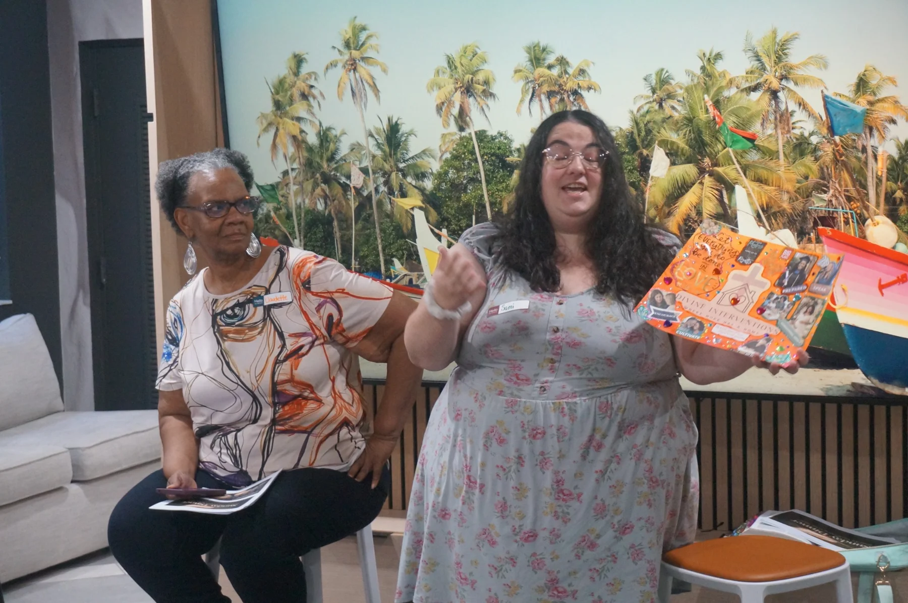 A woman holding her colorful mini-vision board while speaking