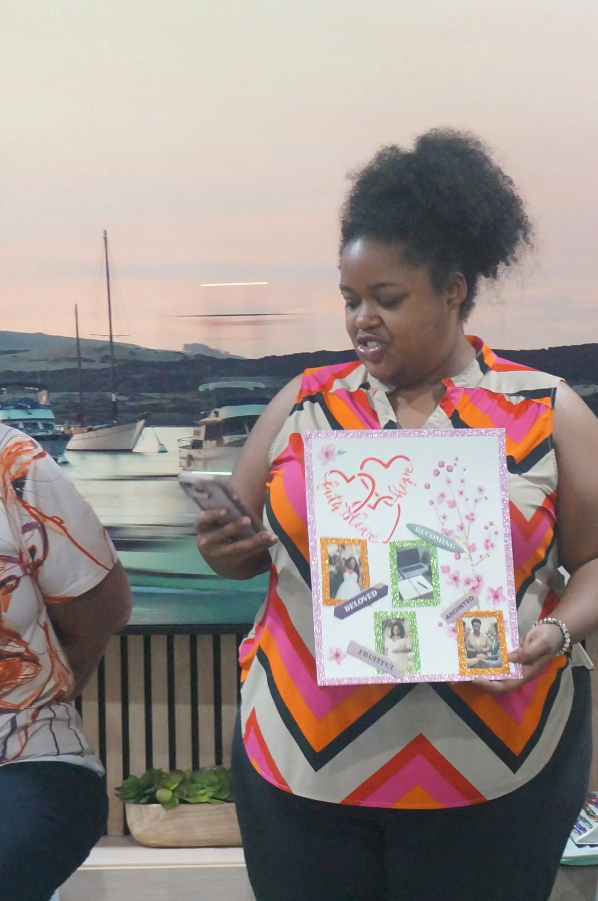 A woman holding her framed mini-vision board