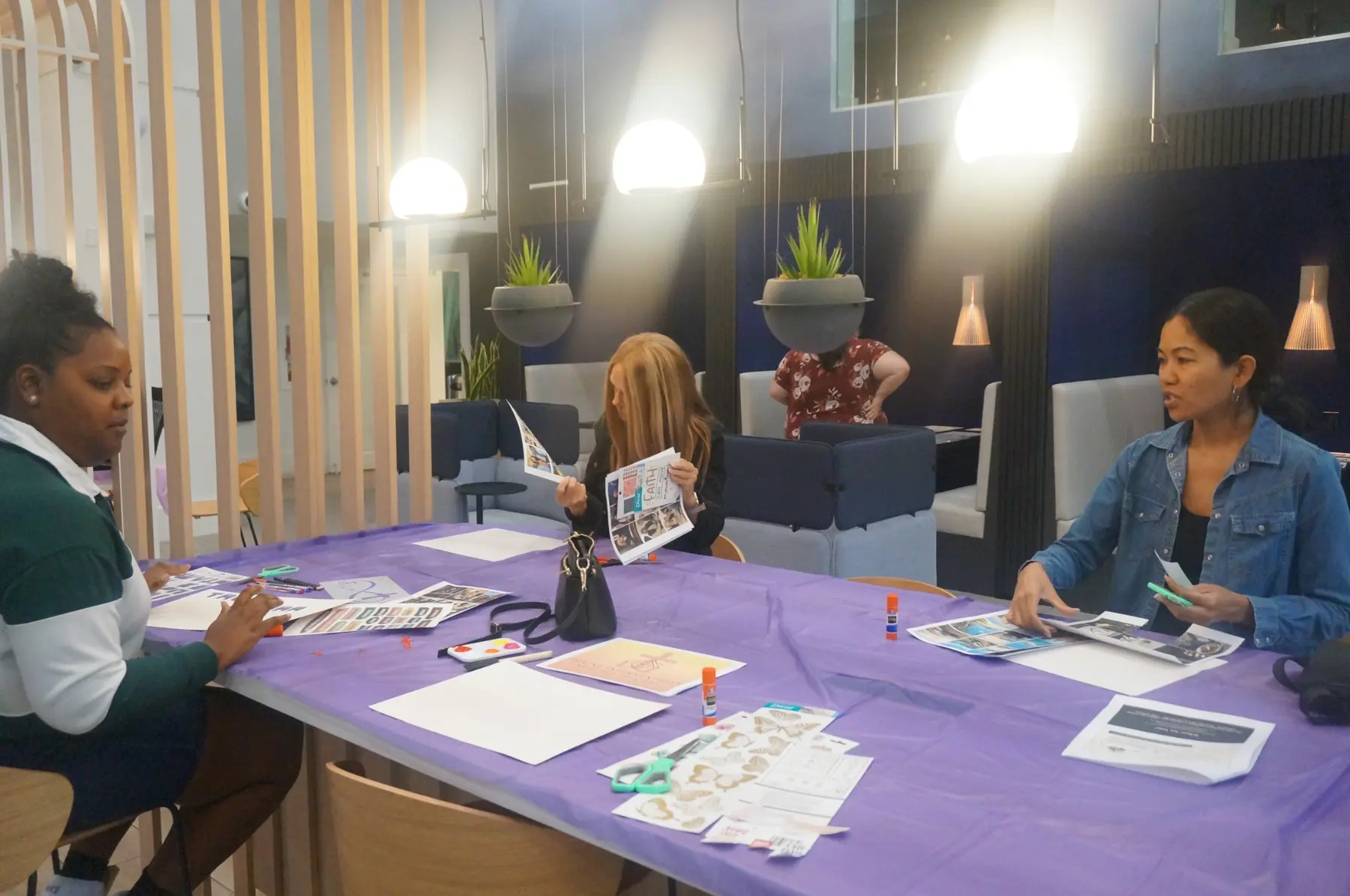 Women gathered around a table creating their mini-vision boards