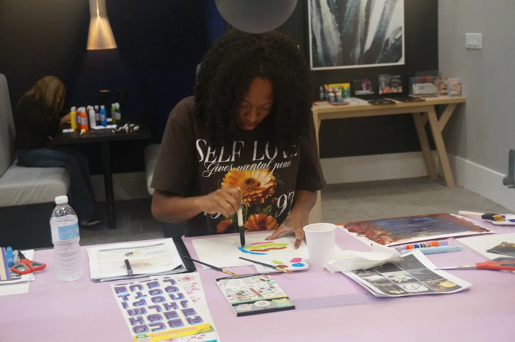 A woman painting the background of her vision board