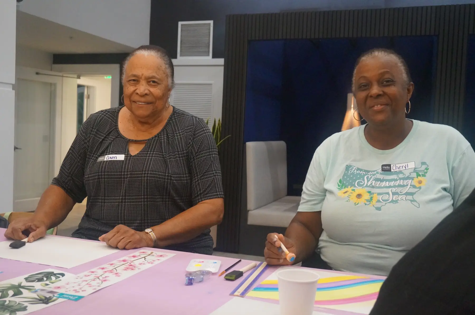 Two women displaying their vision-board work