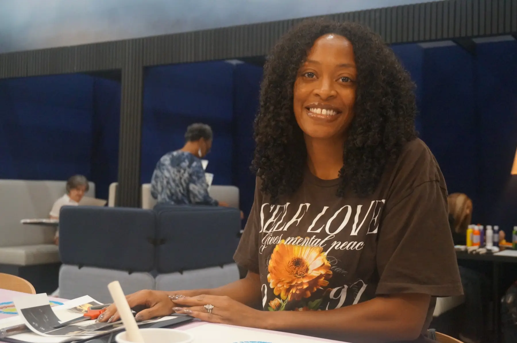 A woman smiling while working on her vision board